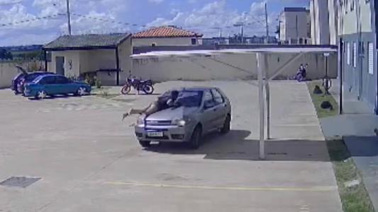 Câmera flagrou momento em que mulher subiu no carro do esposo, que tentava fugir das agressões dela