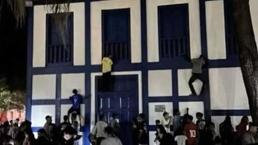Nas imagens, três homens aparecem escalando prédio
