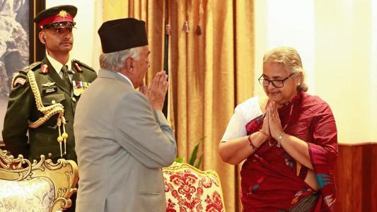 Nepal's President Ram Chandra Paudel (L) gestures after administering the oath to the country's newly appointed Prime Minister Sushila Karki during her swearing-in-ceremony at the President House in Kathmandu on September 12, 2025. Nepal's former chief justice Sushila Karki was sworn on September 12 to lead the transition as the country's next prime minister after deadly anti-corruption protests ousted the government. (Photo by Sujan GURUNG / AFP)