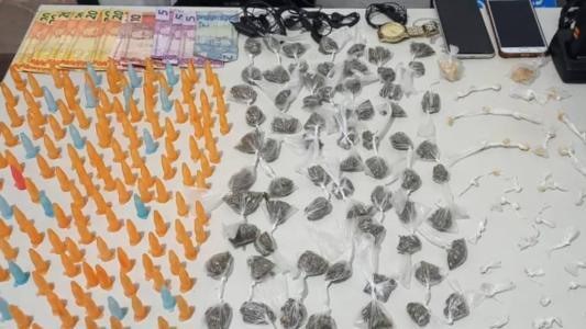 Foram apreendidos 155 pinos de cocaína, 69 buchas de maconha, 49 pedras de crack e R$177,00 em dinheiro.