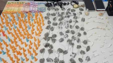 Foram apreendidos 155 pinos de cocaína, 69 buchas de maconha, 49 pedras de crack e R$177,00 em dinheiro.