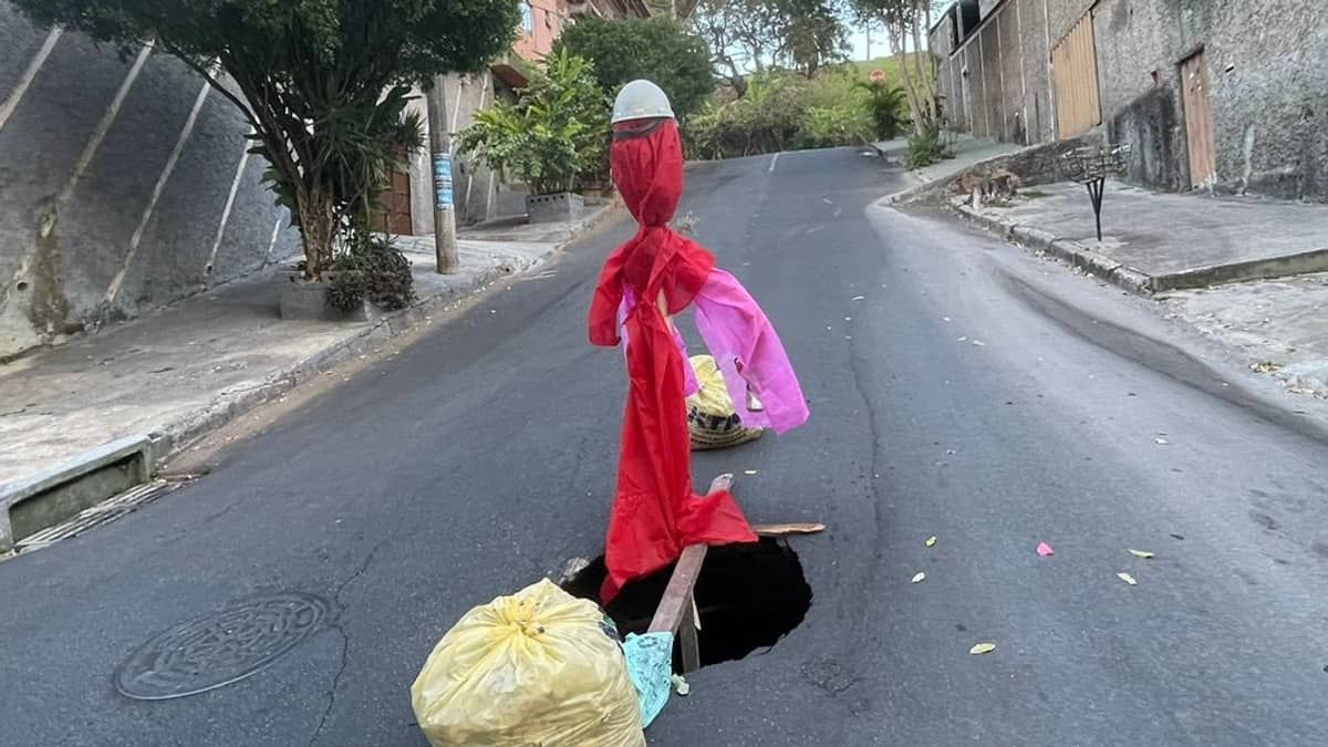 Moradores criam 'boneco' para alertar sobre cratera aberta em rua de BH; veja imagem