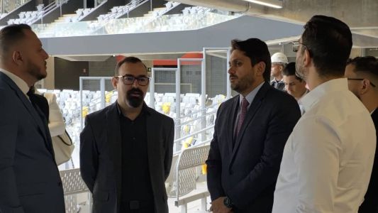 O ministro das Comunicações, Juscelino Filho (de gravata), ao lado do presidente da Abramulti, Jony Cruz, durante evento na Arena MRV nesta quarta-feira (21)