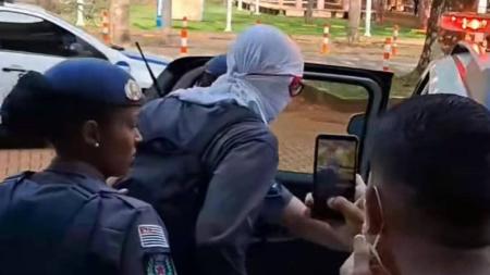 O professor Renato Leão sendo levado à delegacia de polícia depois das ameaças.