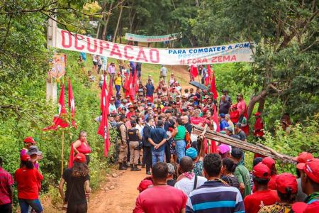 Foto mostra integrantes do MST conversando com policiais e autoridades em fazenda invadida em MG