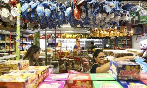 consumidores escolhem doces e ovos de pascoa em supermercado