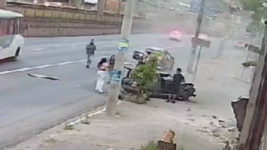 Passageira olha para carro destruído após acidente na avenida Cristiano Machado