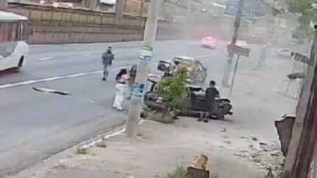 Passageira olha para carro destruído após acidente na avenida Cristiano Machado