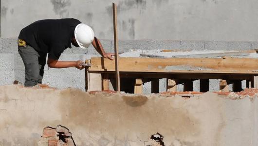 Foto mostra pedreiro trabalhando em obra