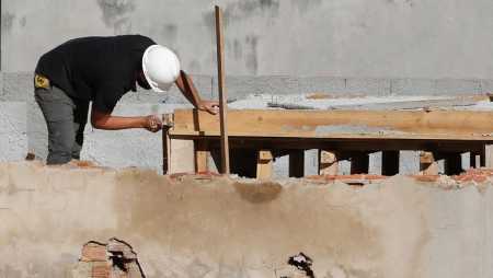Foto mostra pedreiro trabalhando em obra