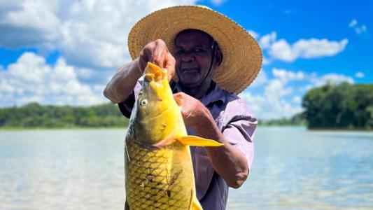 Pescador exibe carpa fisgada na Lagoa da Pampulha