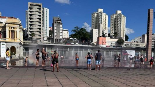 Pessoas aproveitaram o chafariz da Praça da Estação, no Centro de BH, para se refrescarem neste domingo (28) quente