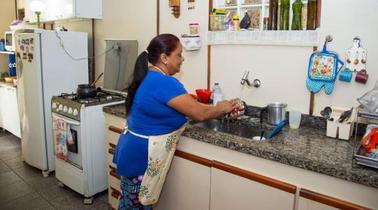 Mulher adulta lavando a louça