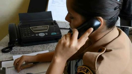 Policial atendendo telefone