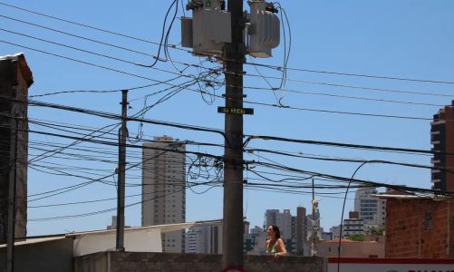Foto mostra poste de energia em grande cidade