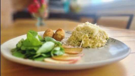 Prato vegano com risoto de brócolis, chips de maçã, salada de agrião e bolinhos de soja empanados