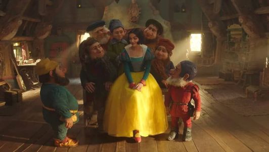 Rachel Zegler como Branca de Neve cercada pelos sete anões