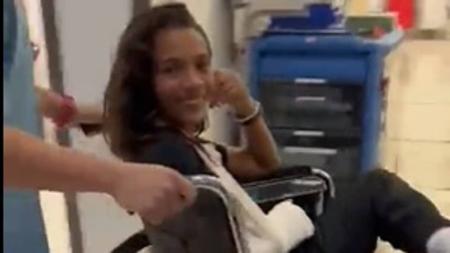 Rayssa Leal sorri após deixar o hospital com o antebraço enfaixado