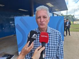 Rogério Correia é um homem branco de cabelos brancos. Na imagem, ele usa camisa de botão listrada azul e fala no microfone da rádio Itatiaia.