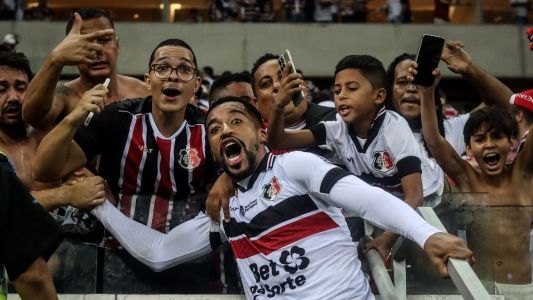 Yuri Ferraz, lateral do Santa Cruz, celebra classificação com a torcida, na Arena de Pernambuco