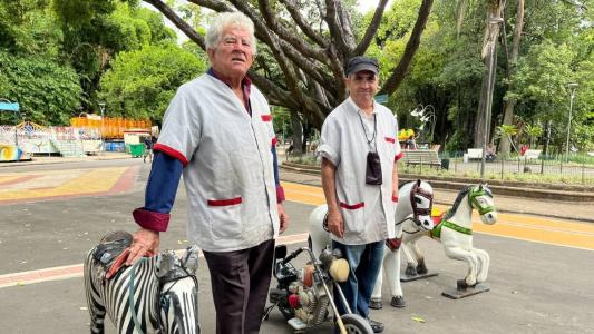 Senhor Xavier (à esq) ensinou o ofício a João Pereira; Parque municipal tem três lambe-lambes