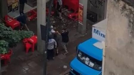 Torcedor com a camisa do Internacional (preta) agride homem com camisa do Nacional com um cacetete