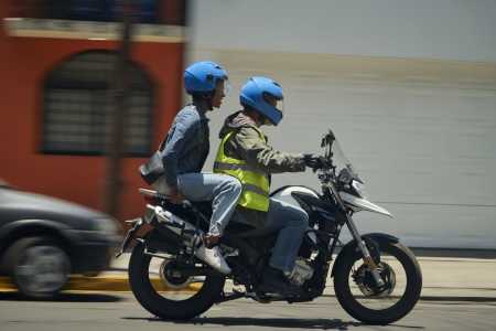 Foto mostra motociclista por aplicativo com passageiro