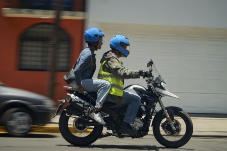 Foto mostra motociclista por aplicativo com passageiro