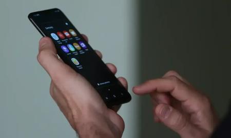 Imagem de uma mão mexendo em um telefone celular