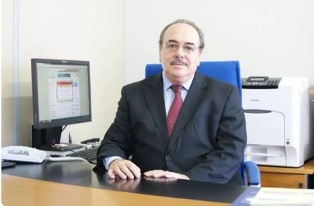 Evaldo Vilela sentado em mesa de escritório ao lado do computador