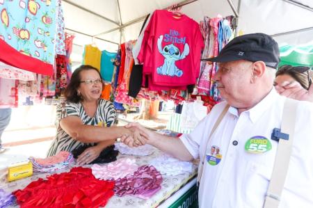 Fuad Noman é um homem branco, de bigode e cabelos brancos. Ele tem olhos claros e na imagem usa uma camisa social laranja claro com um suspensório cinza.