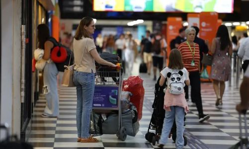 Mãe e filha caminham no saguão de um aeroporto para embarcar em um voo - Rovena Rosa/Agência Brasil
