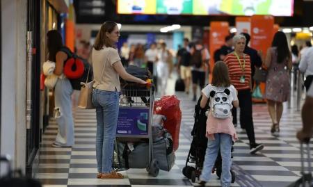 Mãe e filha caminham no saguão de um aeroporto para embarcar em um voo - Rovena Rosa/Agência Brasil