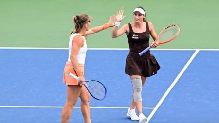 Luisa Stefani (boné branco) e Timea Babos durante quartas de final do US Open