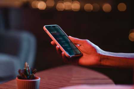 Imagem de uma mão mexendo em um telefone celular