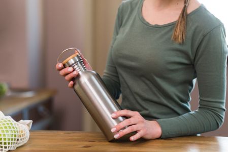 Mulher segurando uma garrafa térmica
