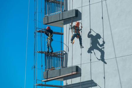Imagem retirada do banco de imagens Free Pik, de trabalhadores suspensos em andaime