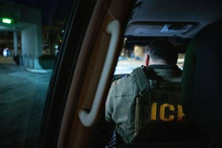 Agente do Serviço de Imigração e Alfândega dos EUA espera em um veículo durante uma operação de fiscalização multiagências em Chicago