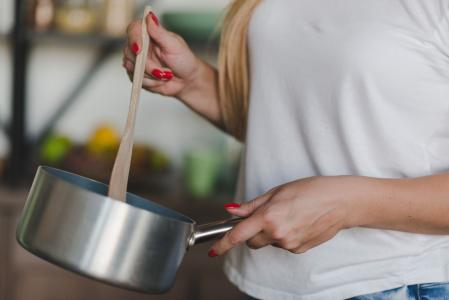 Mulher cozinhando em panela