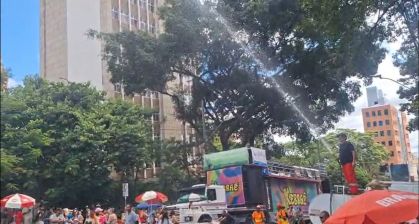 Foliões se refrescam com banho de mangueira durante bloco