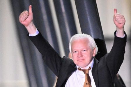 julian assange de terno preto e camisa branca