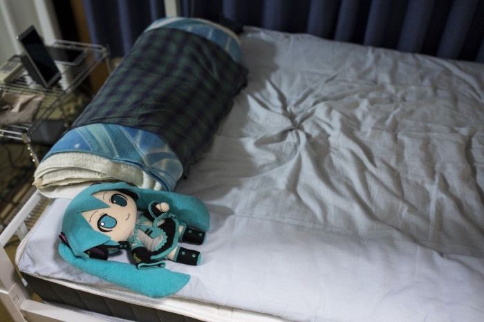 A boneca da cantora japonesa de realidade virtual Hatsune Miku, usando uma aliança de casamento, está deitada na cama do japonês Akihiko Kondo, em seu apartamento em Tóquio, uma semana após seu casamento. A boneca da cantora japonesa de realidade virtual Hatsune Miku, usando uma aliança de casamento, está deitada na cama do japonês Akihiko Kondo, em seu apartamento em Tóquio, uma semana após seu casamento.