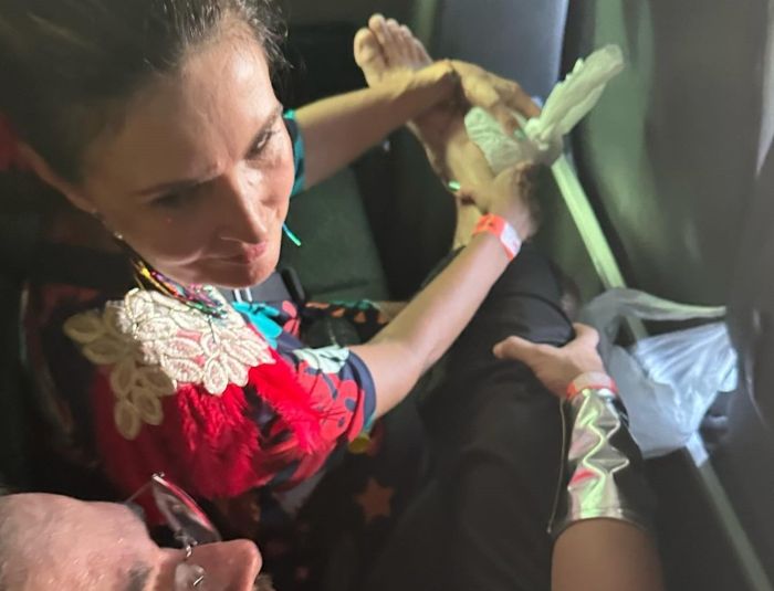 Fátima Bernardes segurando um saco de gelo no pé de Túlio Gadêlha, após o deputado torcer o pé durante folia em Pernambuco