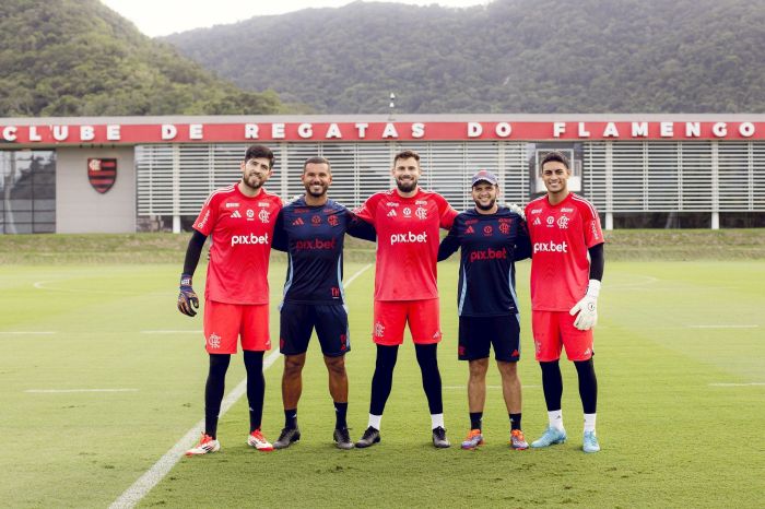 Matheus Cunha, ao centro, ao lado de Agustín Rossi, à esquerda, e Dyogo Alves, à direita, e os preparadores de goleiros do Flamengo