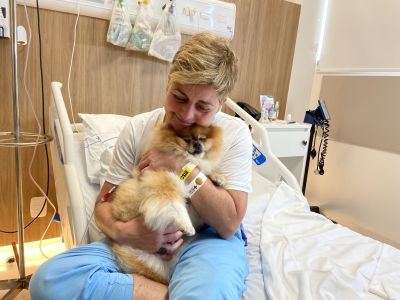 Paciente em hospital segura cachorro no colo