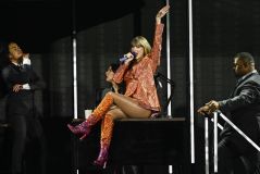 Taylor Swift durante apresentação na 'The Eras Tour' com figurino laranja e rosa