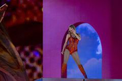 Taylor Swift durante apresentação na 'The Eras Tour' com figurino laranja e rosa