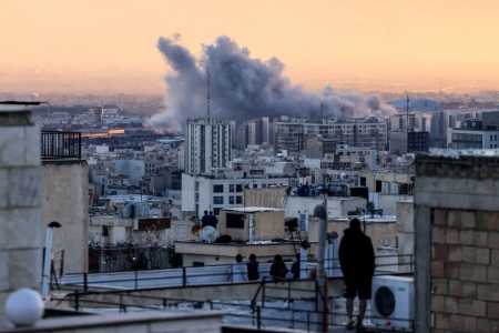 Uma pessoa observa, do telhado de um prédio, uma coluna de fumaça que se eleva após um ataque à capital iraniana, Teerã, em 3 de março de 2026