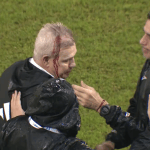 Técnico de seleção deixa campo coberto de sangue ao ser acertado por objeto; assista