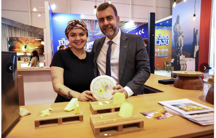 A chef Roberta Gomes e o presidente da Embratur, Marcelo Freixo, com o queijo Canastra no estande de Minas Gerais